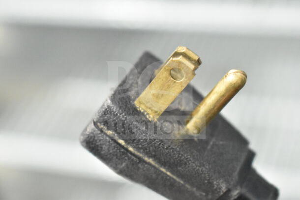Close-up of the plug for a True GDM-12 commercial single door cooler, 115 volts, showing metal prongs.