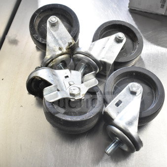 Lot of 4 commercial casters, metal with rubber wheels, slightly used, sturdy design, includes mounting hardware.