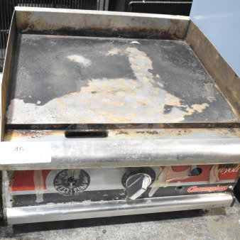 APW Wyott Champion gas-powered flat top griddle, used condition, visible wear and rust, model signage on front panel.
