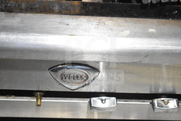 Wells Commercial countertop gas charbroiler grill with visible knobs and Wells logo. Appears to be used condition.