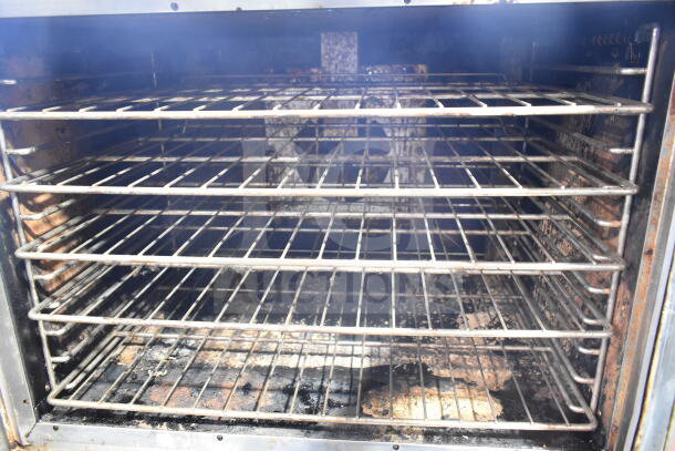 Vulcan Wells VC4GD-11D350K convection oven interior with metal racks, visible wear, view-through doors, and thermostatic controls.