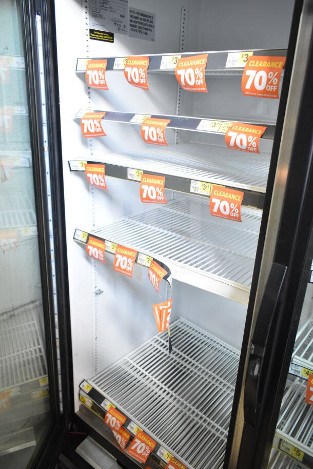 2017 True GDM-72-HC 3-door cooler, commercial grade, 115 volts, 1 phase. Interior shelves with 70% clearance sale tags.