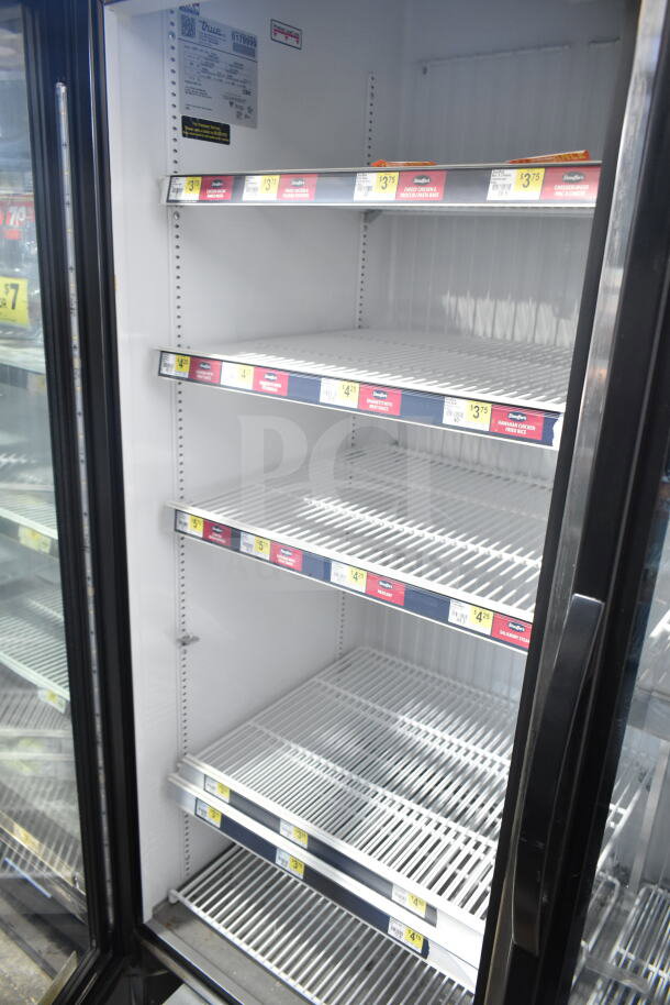 2017 True GDM-72F-HC 3 door commercial freezer with glass doors, adjustable shelves, and visible product pricing labels.
