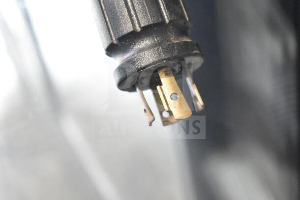 Close-up of a power plug component from a 2017 True GDM-72F-HC commercial freezer merchandiser, showing prongs.
