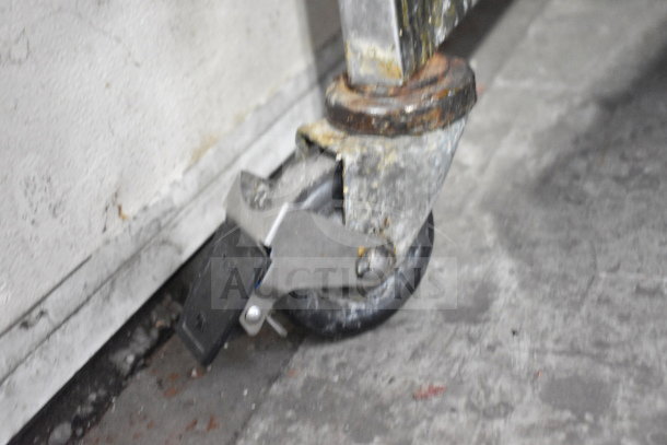 Close-up of a wheel and caster assembly on the Giles EOF-24 commercial fryer, showing wear and surface rust.