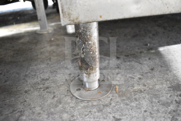Follett SG700S Commercial Ice Bin, showing metal leg base. Evidence of rust; used condition. Ideal for restaurant settings.