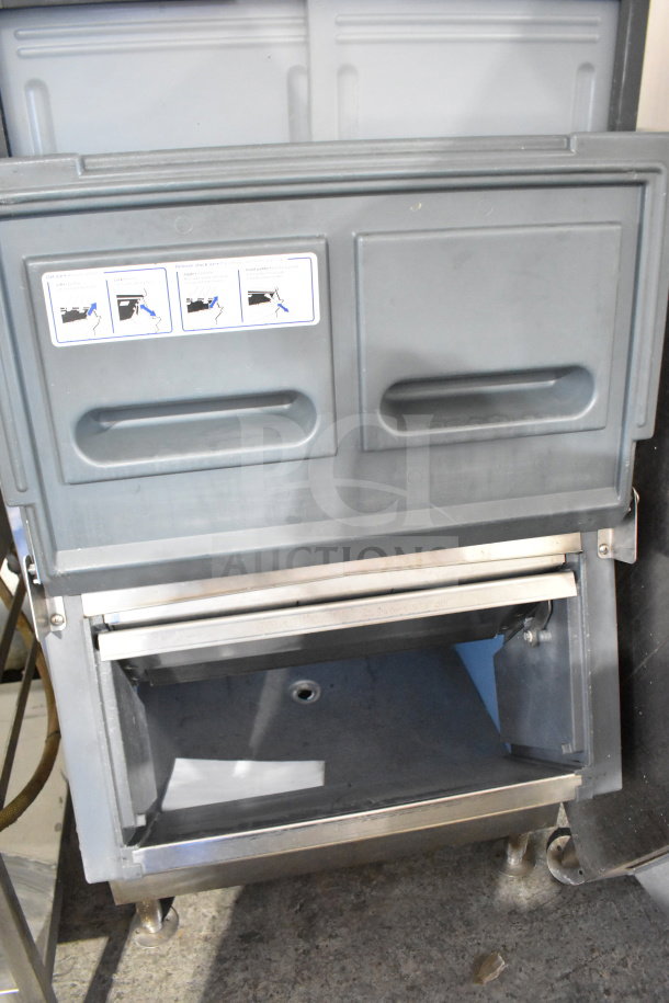 Follett SG700S commercial ice bin, gray, stainless steel trim, open bin door, moderate wear, instruction label visible.