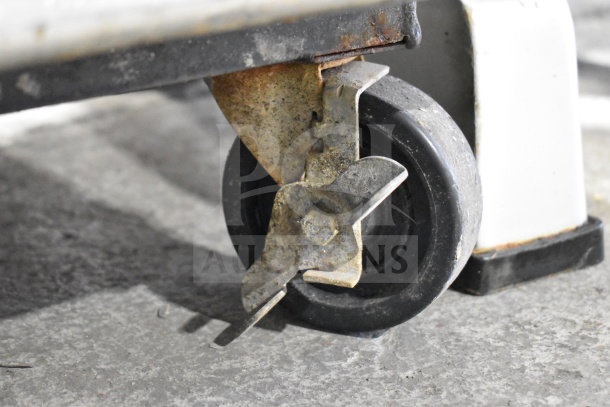 True T-23 Cooler caster close-up, showing condition; commercial-grade wheel with visible wear and securing lock.