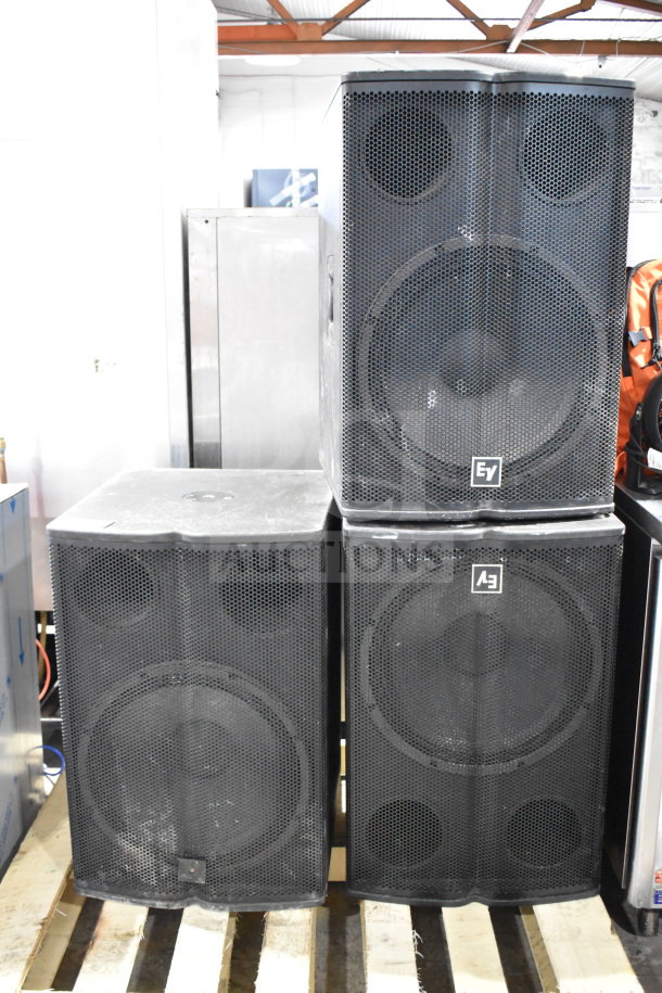 Three Electro Voice EV TX1181 subwoofers, direct radiating design, black casing, sturdy condition, EV branding on front grille.