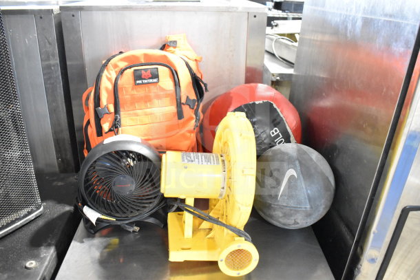 Five items: CFM-222A electric blower, Honeywell HT-900 fan, Fox Tactical orange backpack, red 20 lb ball, black Nike ball.