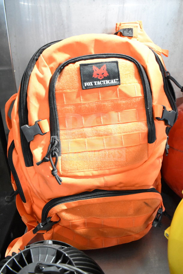 Fox Tactical orange backpack with MOLLE webbing, secure zippers, and a visible logo patch. Rugged and versatile design.