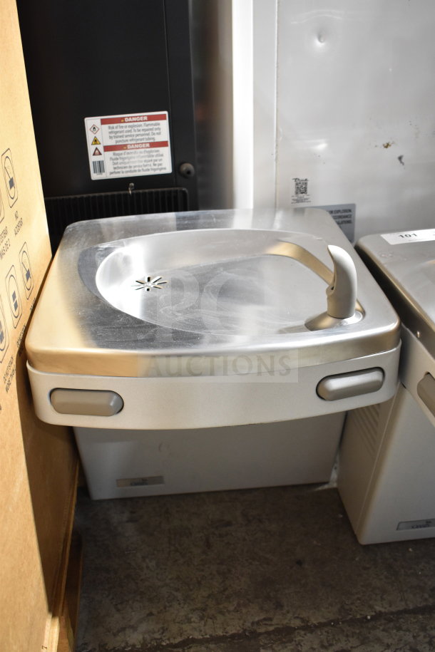 Wall mount water fountain, model PG8ACSL-SK310. Stainless steel, gently used, 115 volts, 1 phase. Safety label visible.