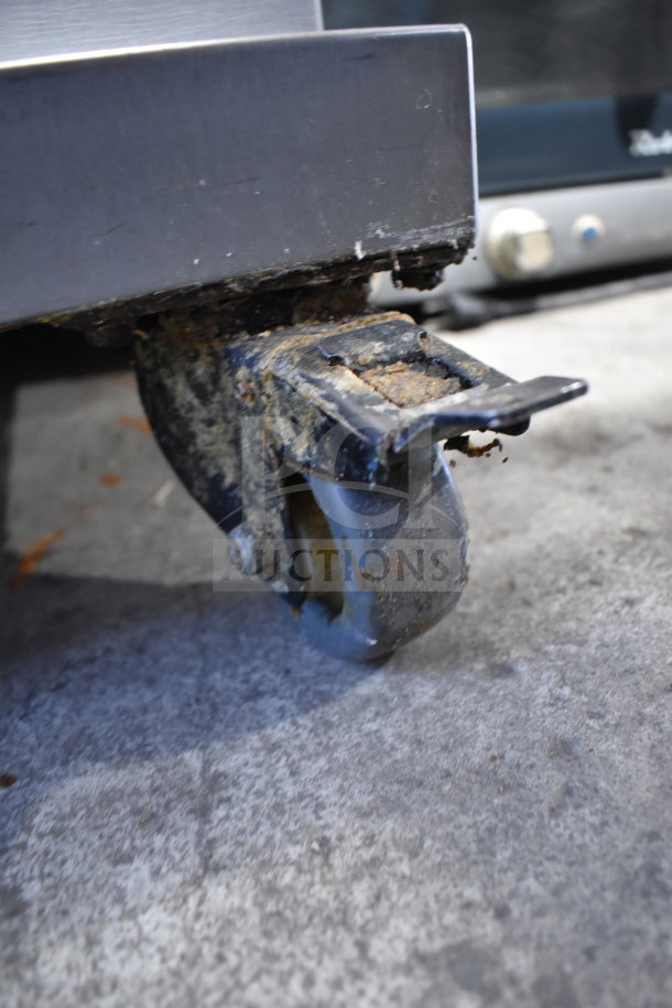 Fri-jado TDR 7-P rotisserie oven caster showing signs of wear on the wheel and metal frame, suitable for commercial use.