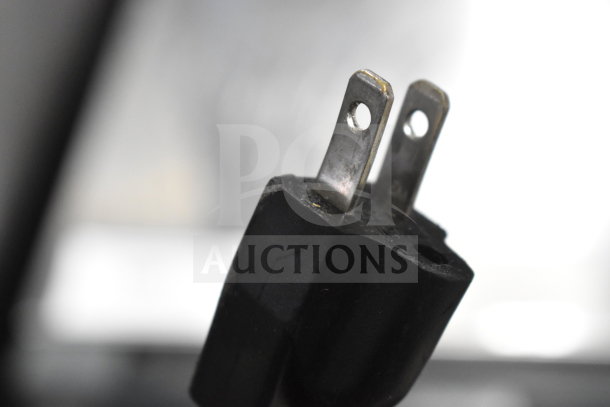 Close-up of a 120-volt plug for a 2023 Cadco Unox XAF003-US Roberta countertop electric convection oven, showing metal prongs.