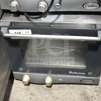 Cadco Unox XAF003 Roberta convection oven, metal, 120V, 1 phase, countertop model, used, visible dials and branding.