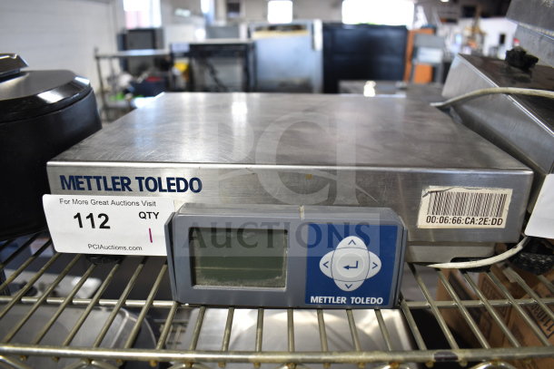 Mettler Toledo BC Commercial Countertop Food Portioning Scale with digital display, barcode, and lot tag on metal surface.