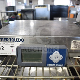 Mettler Toledo BC Commercial Countertop Food Portioning Scale with digital display, barcode, and lot tag on metal surface.