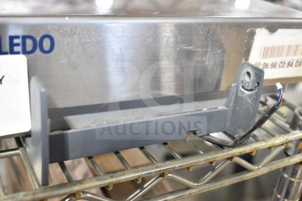 Mettler Toledo BC Commercial Food Scale on shelf, worn condition, exposed wires, label with barcode partially visible.