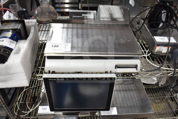 Mettler Toledo countertop food portioning scale, stainless steel, with digital display, appears in used condition, auction tag visible.