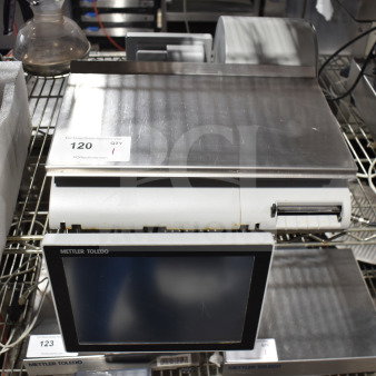 Mettler Toledo countertop food portioning scale, stainless steel, with digital display, appears in used condition, auction tag visible.