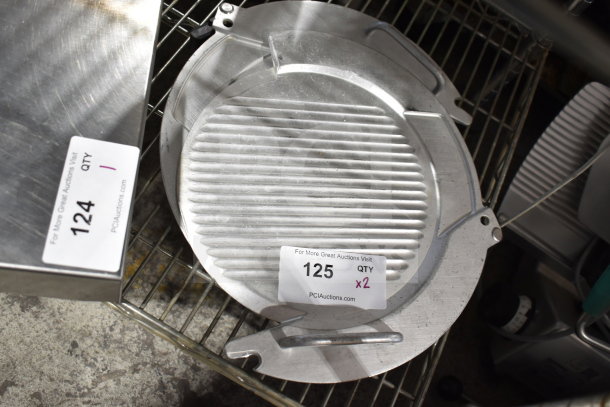 Two metal meat slicer components with ridged surfaces, auction tag "125, QTY x2" from PCIAuctions.com.