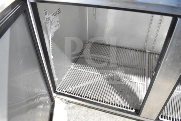 True TPP-67 commercial pizza prep table, silver interior, double doors open, showing wire shelves, 115 volts, 1 phase.