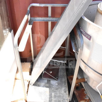 Commercial baking pan rack with multiple shelves on sturdy commercial casters, metal frame, good condition, outdoors.
