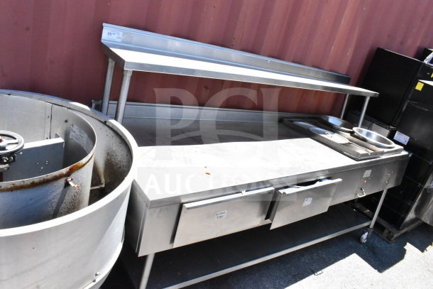 Commercial table with two drawers, upper shelf, lower shelf, and heated well, stainless steel, used condition.