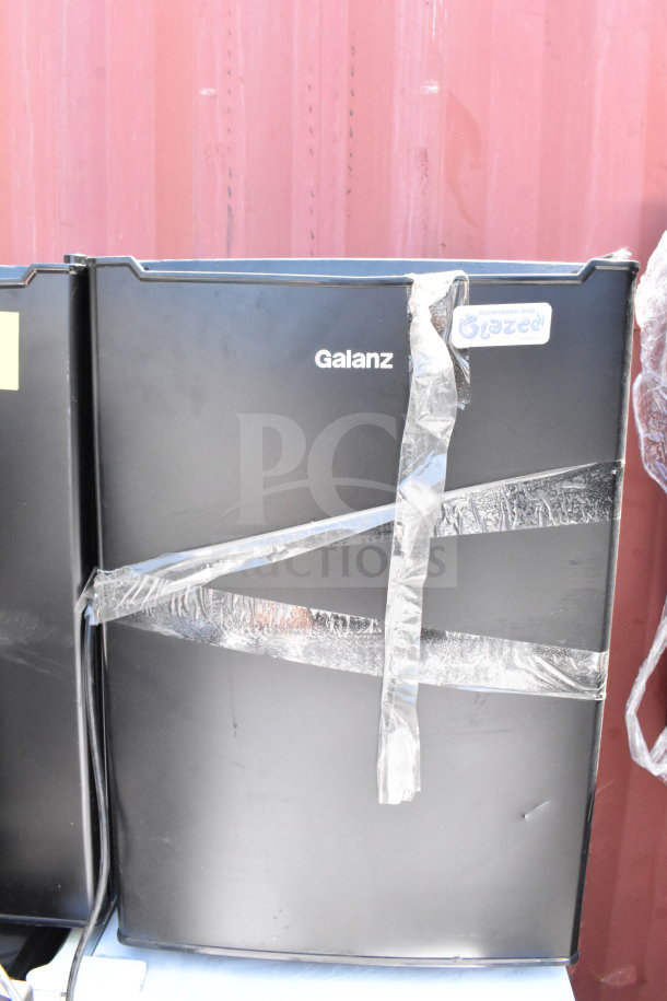 Seven mini coolers including Galanz, Hisense; 115 volts, 1 phase. Black finish, auction lot, visible wear and tape.