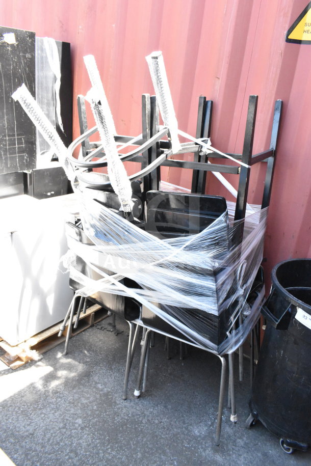 Stack of 11 dining height chairs wrapped in plastic, with metal legs and black seats, in good condition.