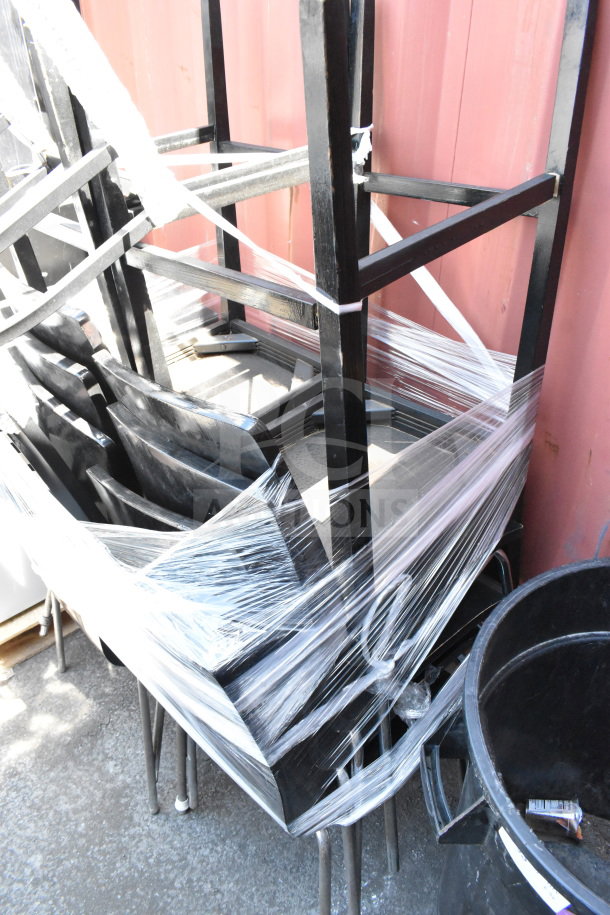 Stack of 11 black dining height chairs, wrapped in plastic. Sturdy metal legs, good condition. Auction lot.