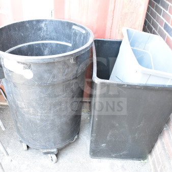 Three black and gray trash cans, various sizes, used condition. One with wheels. Industrial settings. Auction item: 3 times bid.