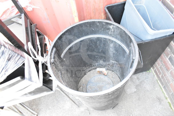 Three trash cans in various sizes and materials, slightly worn condition, for auction. Includes a cylindrical black can and a rectangular blue bin.