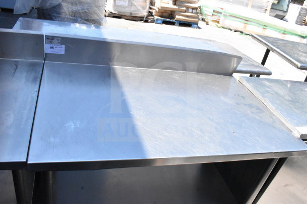 Winholt commercial table with backsplash, under shelf; stainless steel, good condition. Visible tag reads "96 MA."