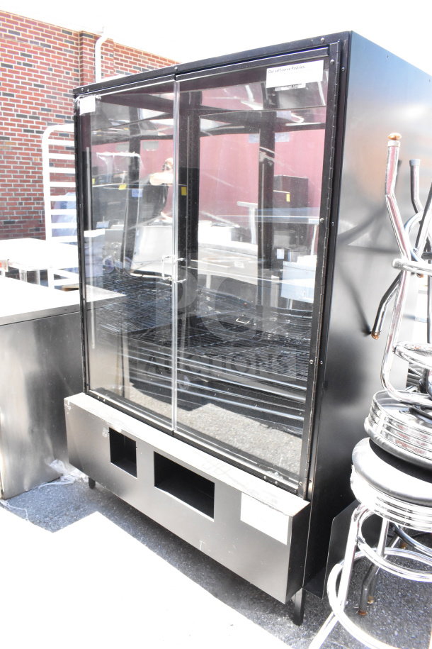 Commercial dry bakery bagel pastry display case merchandiser with glass doors, black exterior, and adjustable shelves. Visible wear.