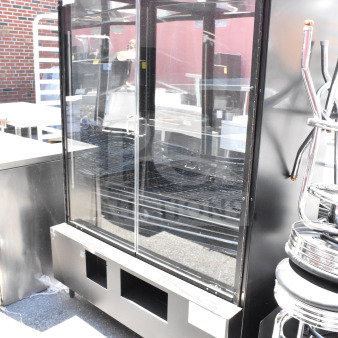 Commercial dry bakery bagel pastry display case merchandiser with glass doors, black exterior, and adjustable shelves. Visible wear.
