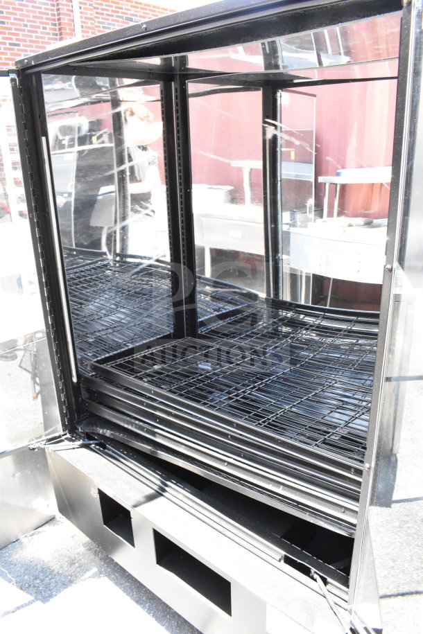 Commercial dry bakery display case with glass shelves and black metal frame, suitable for bagels and pastries.