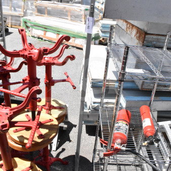 Metal coat rack with hooks, silver finish, in used condition. Auction tag attached, number 96. Outdoor warehouse setting.