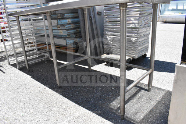 Stainless steel commercial table with sturdy legs and crossbars. Appears in used condition suitable for industrial use.