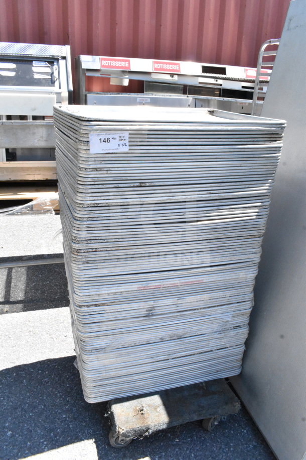Stack of 102 full-size baking pans, silver, used condition. Auction tag reads "Lot 146, QTY 102." Ideal for bulk purchase.