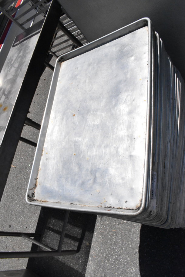 Stack of full-size baking pans, showing moderate wear, offered at auction as a lot of 102.