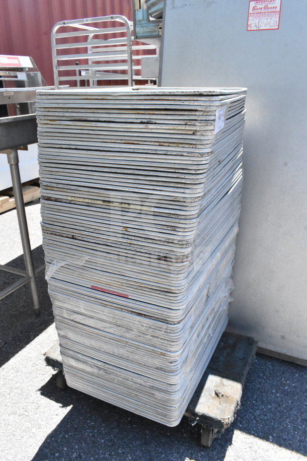 Stack of 102 full-size baking pans on a dolly. Slight wear, suitable for bulk purchase. Winning bid multiplied by 102.
