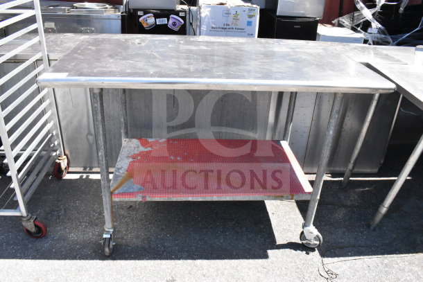 Commercial table with under shelf, mounted can opener, on commercial casters. Shows moderate wear, suitable for kitchen use.
