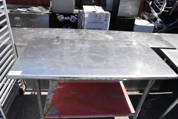 Commercial stainless steel table with under shelf, mounted can opener bracket, and casters; shows wear.