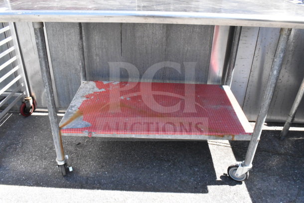 Commercial table with under shelf, can opener mount, on casters. Metal surface, red shelf, visible wear and rust.