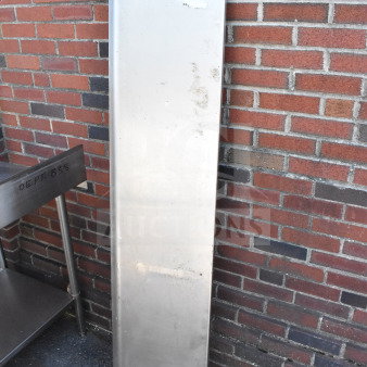 Metal shelf leaning against a brick wall. Slightly worn condition with visible marks. Tag reads "155".