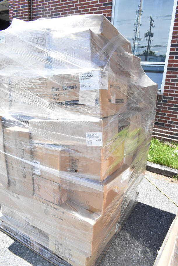 Plastic-wrapped pallet of new assorted items including mop, platters, 23-gallon can, platters, and pilsner glasses. Labels visible.