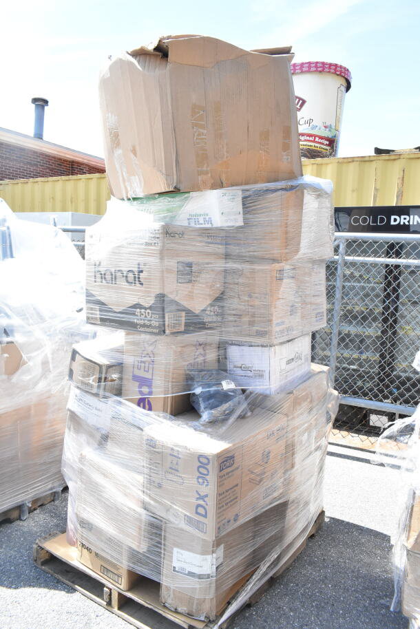 Pallet of assorted scratch and dent items wrapped in plastic, including boxes labeled "Karat" and "FedEx." Items include shot glasses, plates, towels, and paper bags.