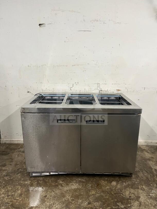 Delfield 4448NP-18M 48" refrigerated salad prep table with 18 pans, stainless steel, visible wear on exterior, functional.