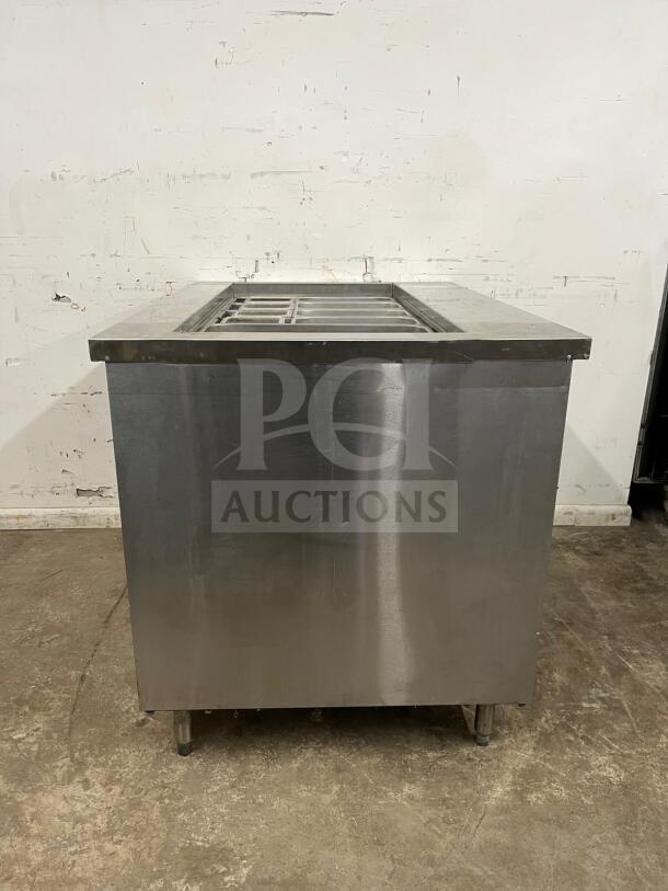 Stainless steel prep table with integrated salad bar, excellent condition, commercial-grade, includes compartments for ingredients.